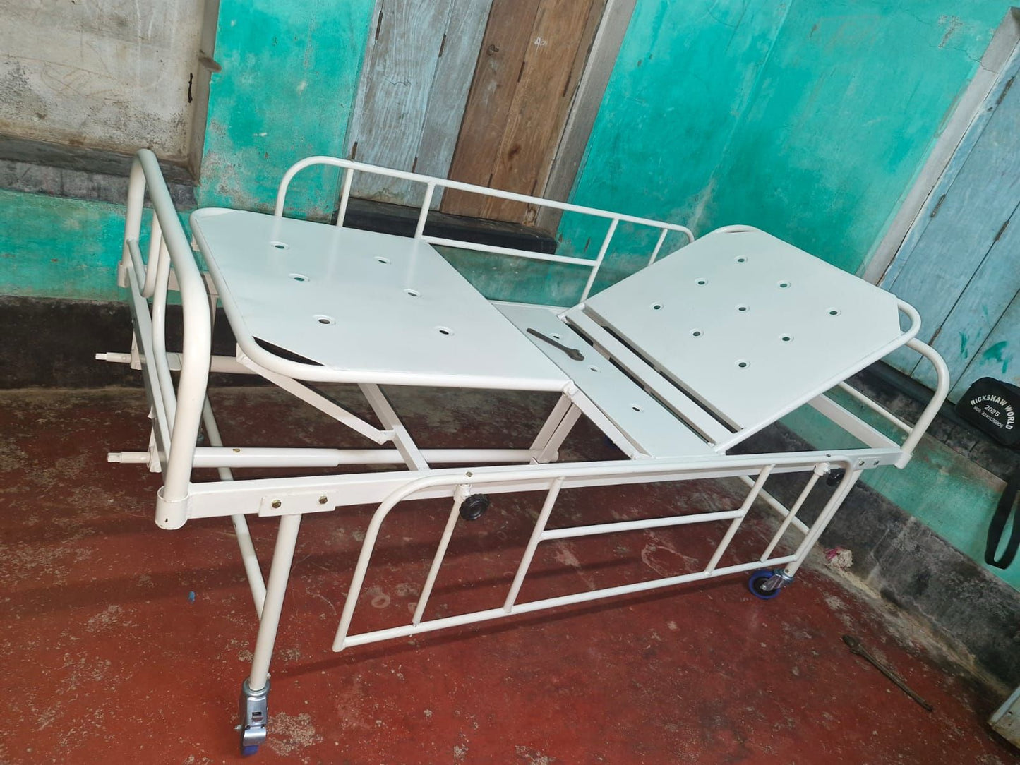 White metal hospital bed against a green wall and red floor